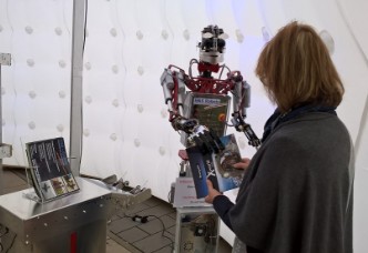 Humanoider Roboter überreicht Werbeprospekt, by Ben Schaefer